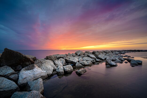 Vista affascinante del tramonto sulle pietre del mare