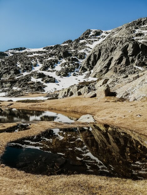 Vista affascinante dell'acqua che riflette l'ambiente circostante nella montagna di Penalara in Spagna