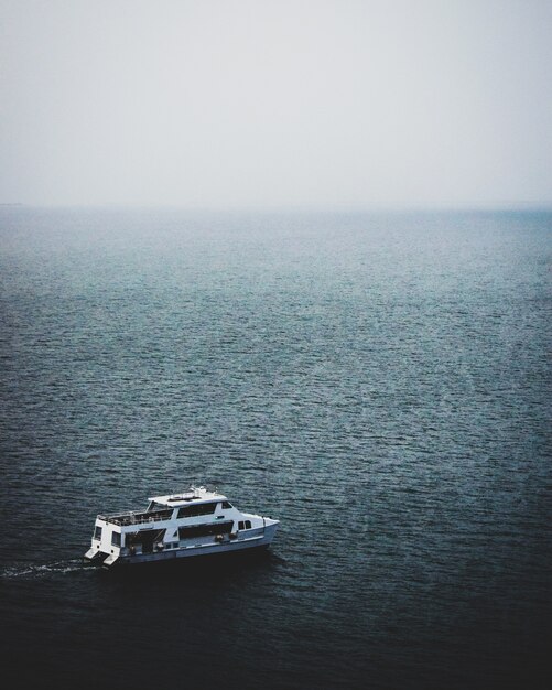 Vista affascinante della barca nel mare calmo in una giornata nebbiosa