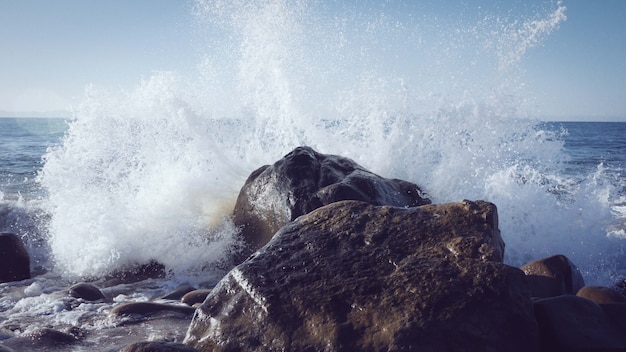 Vista affascinante delle onde dell'oceano che si infrangono contro le rocce vicino alla riva