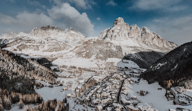 Vista affascinante di una piccola città in inverno circondata da montagne rocciose coperte di neve