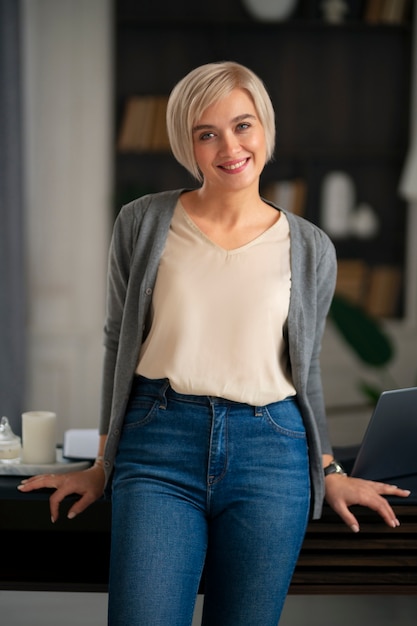 Vista anteriore donna sorridente che posa all'interno