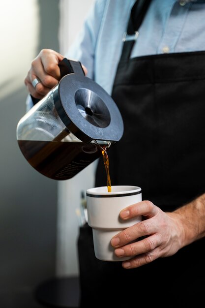 Vista anteriore uomo che versa il caffè