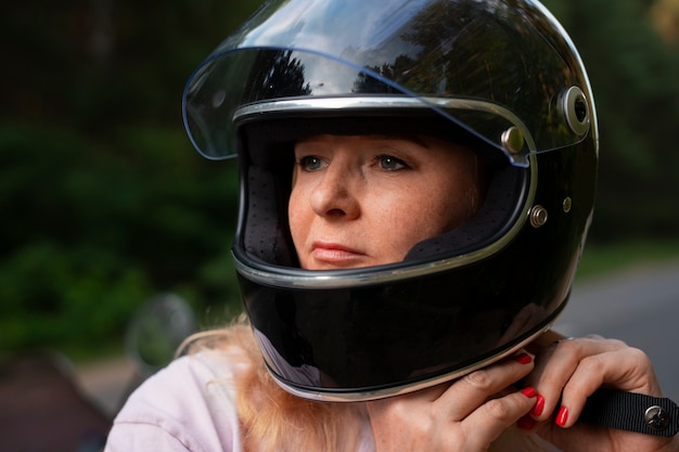 Vista anteriore vecchia donna cool con moto