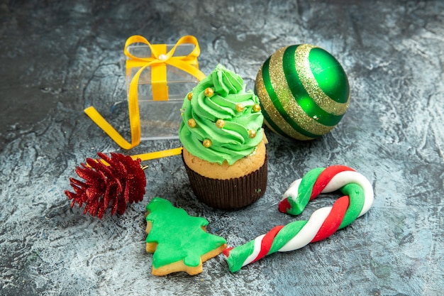 Vista dal basso albero di natale cupcake caramelle di natale albero di natale giocattoli su sfondo grigio foto di capodanno