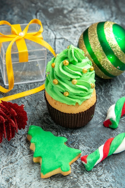 Vista dal basso albero di natale cupcake caramelle di natale albero di natale giocattoli su sfondo grigio