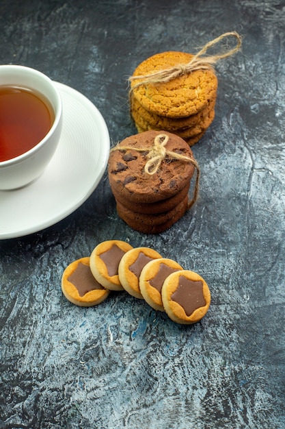 Vista dal basso di una tazza di biscotti da tè legati con una corda sul tavolo grigio