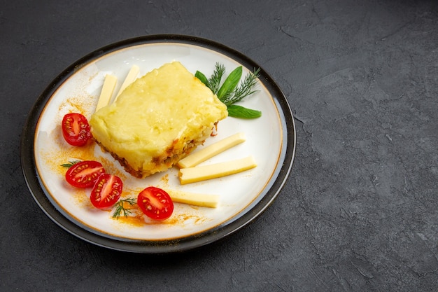 Vista dal basso gustose lasagne sul piatto su sfondo scuro copia posto