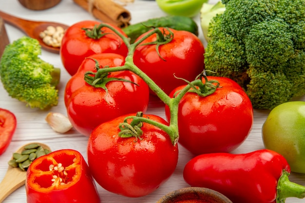 Vista dal basso ramo di pomodoro broccoli cucchiai di legno aglio sul tavolo grigio