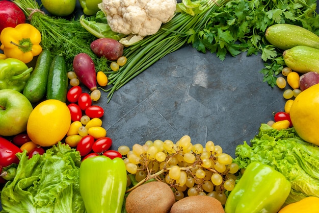 Vista dal basso verdura e frutta lattuga cumcuat zucchine peperoni kiwi uva prezzemolo cipolla verde cavolfiore pomodorini limone spazio libero