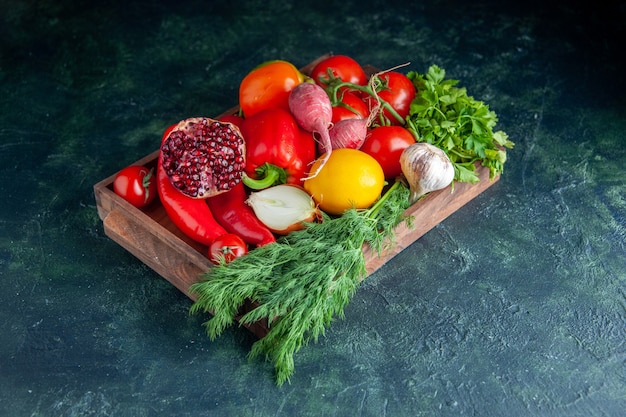 Vista dal basso verdure fresche e mezzo melograno su tavola di legno su grigio