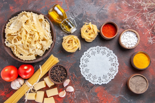 Vista dall'alto a fette di pasta cruda con condimenti sulla superficie scura pasta pasta scura