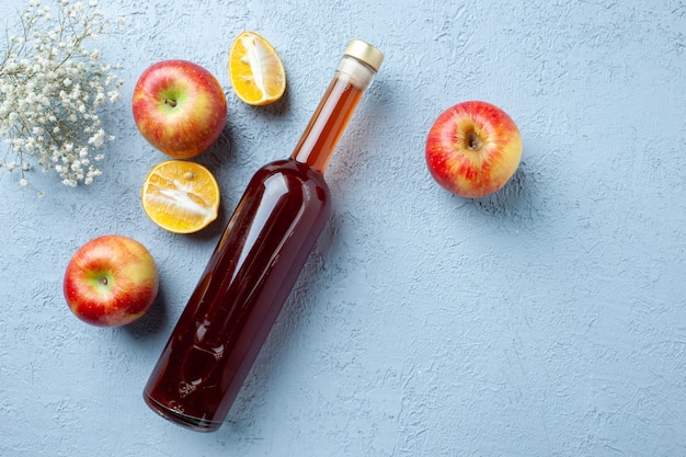 Vista dall'alto aceto di mele in bottiglia su sfondo bianco succo di frutta foto a colori bevanda fresca cibo aspro