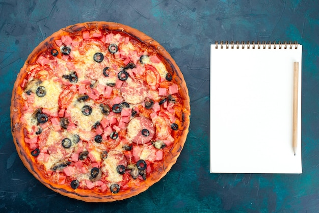 Vista dall'alto al forno deliziosa pizza con olive salsicce e formaggio su sfondo azzurro.