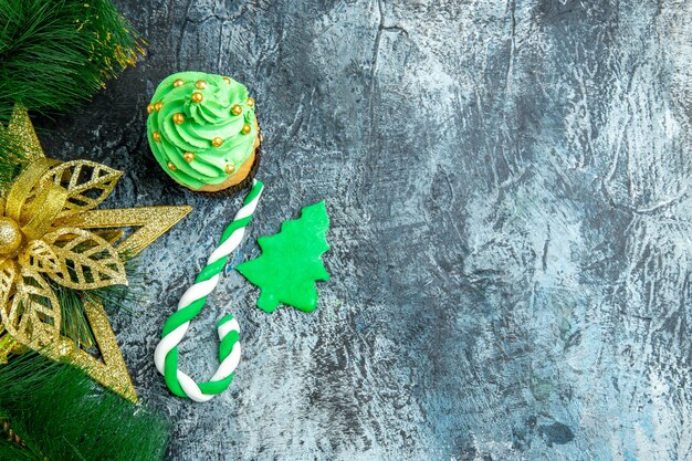 Vista dall'alto albero di natale cupcake natale caramelle ornamenti di natale su superficie grigia