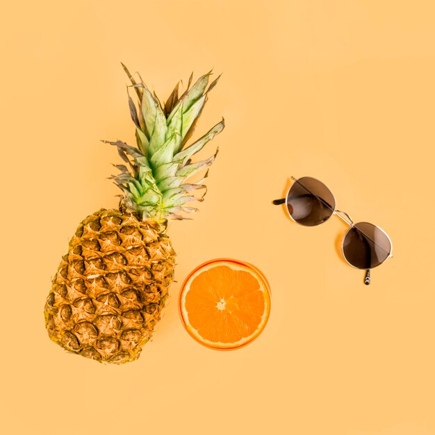 Vista dall&#39;alto ananas, arancia e occhiali da sole