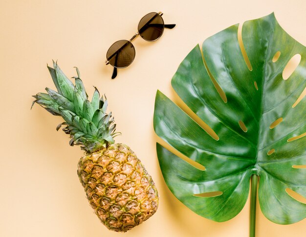 Vista dall'alto ananas con occhiali da sole e foglia