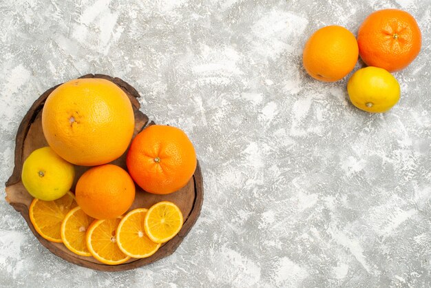 Vista dall'alto arance fresche con mandarini su sfondo bianco agrumi maturi frutta fresca tropicale esotica