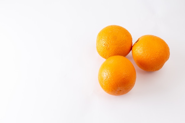 Vista dall'alto arance fresche intere succose e aspre su sfondo bianco agrumi esotici colore frutta