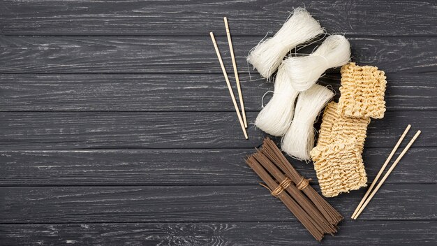 Vista dall'alto assortimento di noodles crudi e bacchette con spazio di copia