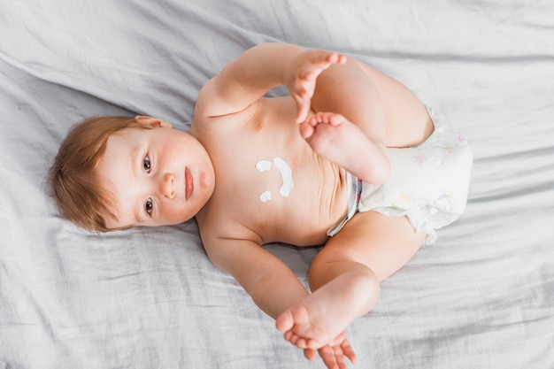 Vista dall&#39;alto bambino spalmato con lozione