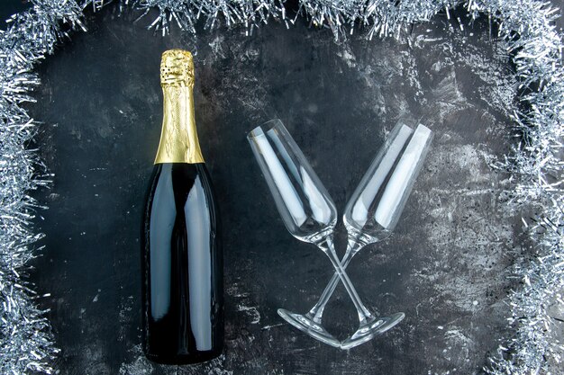 Vista dall'alto bicchieri di champagne incrociati con champagne sul tavolo scuro