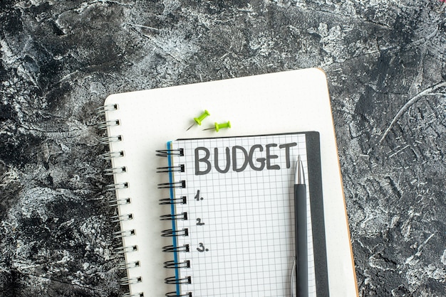 vista dall'alto bilancio nota scritta sul blocco note con la penna sulla superficie scura studente quaderno di colore scuola grigio college business