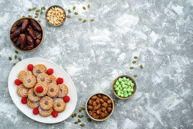 Vista dall'alto biscotti dolci con caramelle e confitures su sfondo bianco biscotto zucchero biscotto torta tè dolce