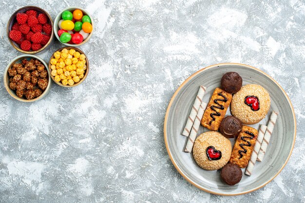 Vista dall'alto biscotti dolci con confitures e noci su sfondo bianco dado zucchero candito biscotto torta dolce torta