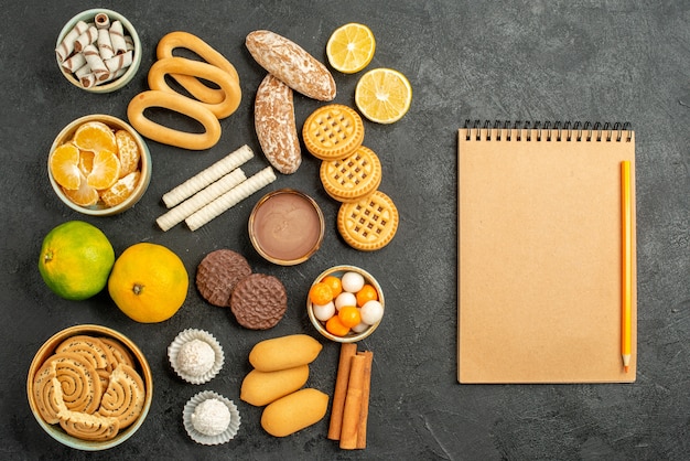 Vista dall'alto biscotti dolci con frutta e biscotti su sfondo grigio