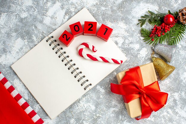 Vista dall'alto blocchi di legno caramelle natalizie su notebook dettagli natalizi su sfondo grigio bianco