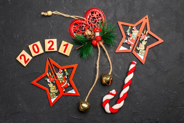 Vista dall'alto blocco di legno ornamenti di natale caramelle di natale su sfondo scuro isolato