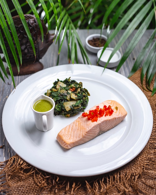 Vista dall'alto bollito pesce rosso con verdure stufate e salsa su un piatto