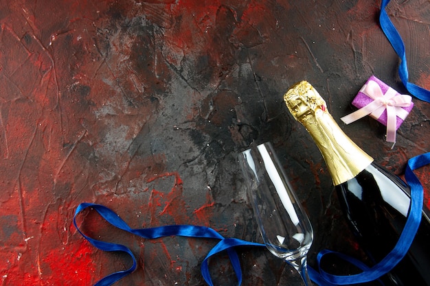 Vista dall'alto bottiglia di champagne con bicchiere di vino sul colore della foto alcolica bevanda scura drink