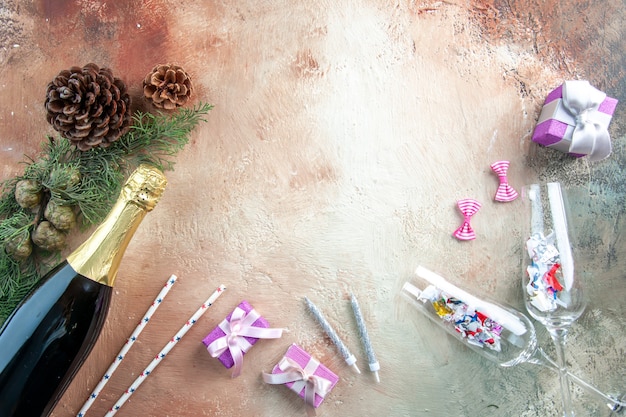 Vista dall'alto bottiglia di champagne con piccoli regali su luce natale foto capodanno colore regalo alcol