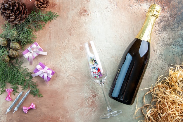 Vista dall'alto bottiglia di champagne con piccoli regali sul regalo di luce natale foto capodanno colore alcol