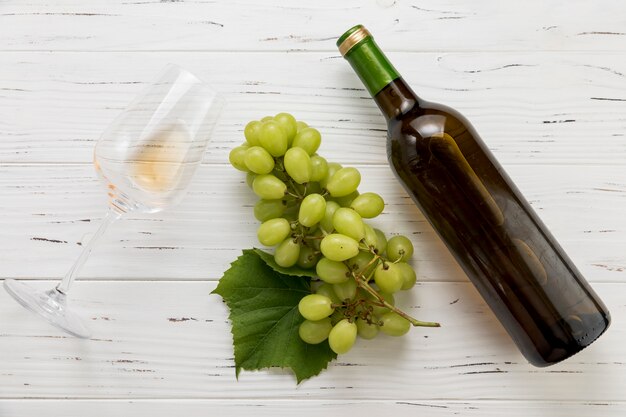 Vista dall&#39;alto bottiglia di vino con vetro e grappolo d&#39;uva