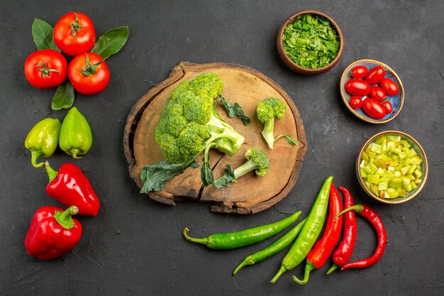 Vista dall'alto broccoli freschi con pomodori e peperoni sul colore insalata matura tavolo scuro