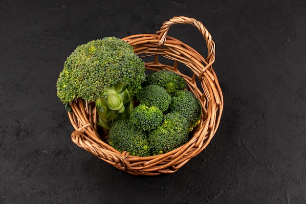 vista dall'alto broccoli verdi freschi maturi all'interno del cestino sul buio