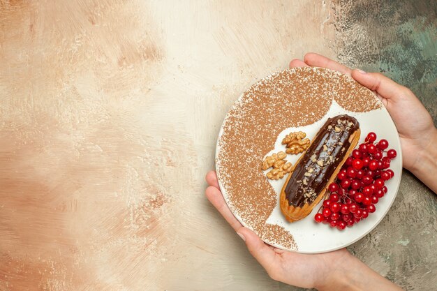 Vista dall'alto buonissimo eclair con bacche rosse sul dessert torta dolce tavolo leggero