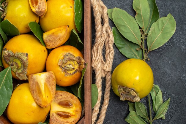 Vista dall'alto cachi dolci freschi all'interno della scatola sul gusto di frutta matura tavolo scuro