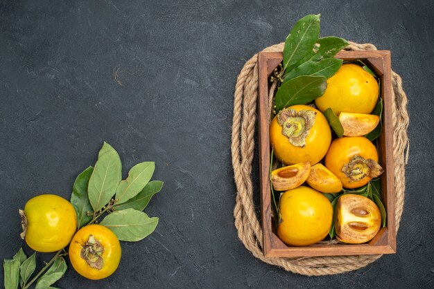 Vista dall'alto cachi dolci freschi all'interno della scatola sul gusto di frutta matura tavolo scuro