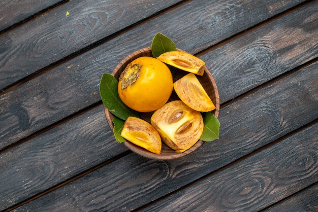 Vista dall'alto cachi dolci freschi su un tavolo rustico in legno, dolce salute della frutta