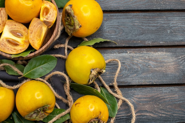 Vista dall'alto cachi dolci freschi sulla tavola rustica in legno, frutta matura