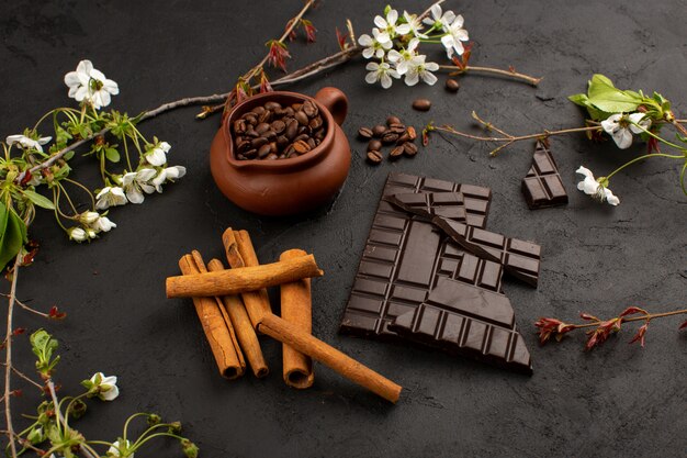 vista dall'alto caffè al cioccolato alla cannella insieme a fiori bianchi sul pavimento scuro