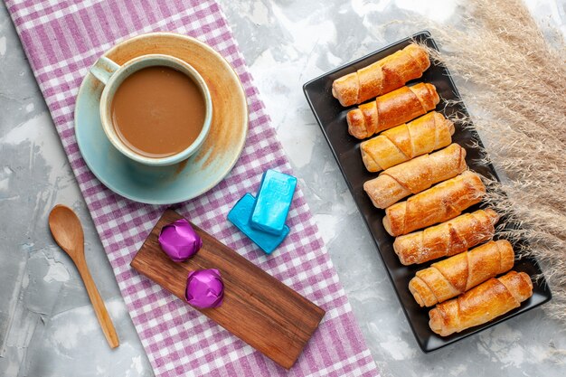 Vista dall'alto caffè al latte con braccialetti sulla scrivania grigia pasticceria dolce biscotto zucchero