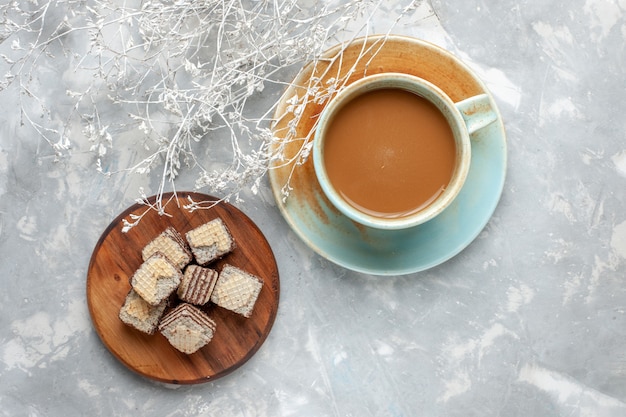 Vista dall'alto caffè al latte con cialde al cioccolato sul biscotto torta di zucchero dolce scrivania grigia