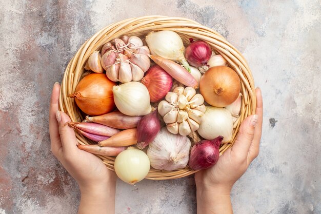 Vista dall'alto cipolle e aglio ingredienti freschi all'interno del cestello