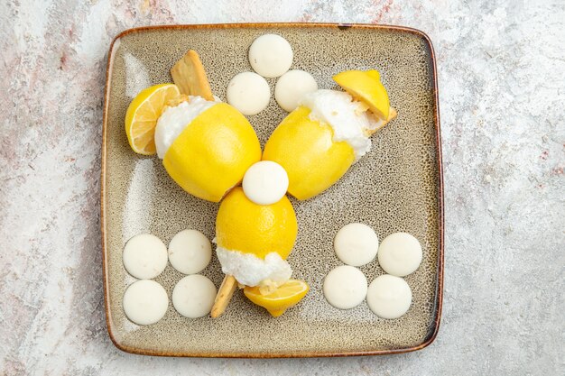 Vista dall'alto cocktail al limone con caramelle bianche sul succo di cocktail drink di frutta tavolo bianco