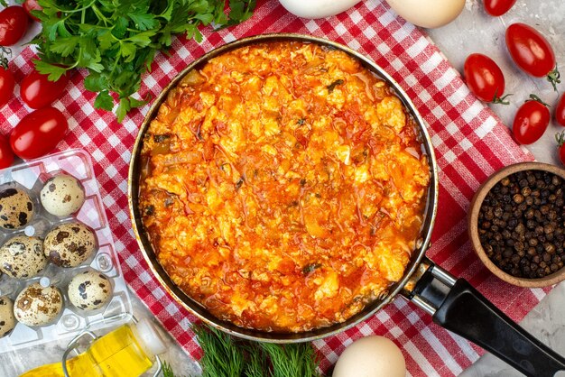 Vista dall'alto colazione cucinata uova fritte e pomodori con ingredienti diversi su sfondo bianco pranzo mattutino pasto all'uovo pane colore della famiglia